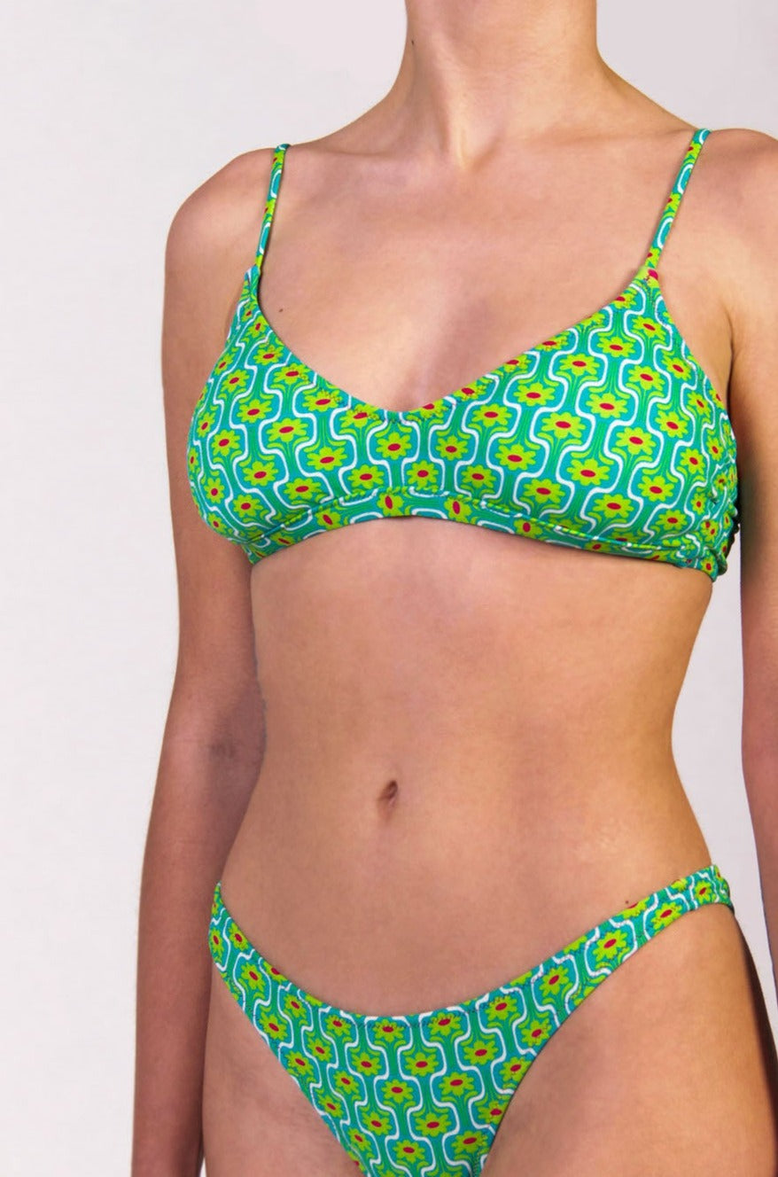 Bikini con top bralette in fantasia floreale verde con interno e cuciture a contrasto colore fucsia Bralette con coppe estraibili e chiusura metallica Spalline mobili da allacciare dietro al collo o dietro la schiena Slip con fianco unito 100% Made in Italy