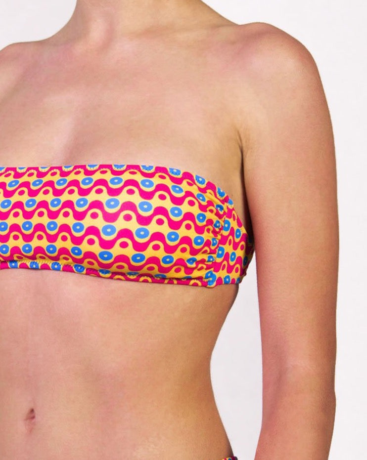 Bikini con fascia in fantasia geometrica colore giallo, fucsia e blu con interno e cuciture a contrasto colore blu Fascia con coppe estraibili e chiusura con laccetti sottili Slip con fianco unito Morbida Lycra 100% Made in Italy