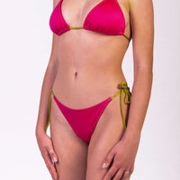 Bikini con triangolo e slip con laccetti tinta unita colore fucsia satinato, con laccetti e cuciture a contrasto colore verde Triangolo scorrevole con coppe estraibili Slip con laccetti sottili Morbida Lycra 100% Made in Italy