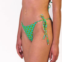 Bikini in fantasia verde floreale con triangolo e slip con laccetti, interno e cuciture a contrasto colore fucsia Triangolo scorrevole con coppe estraibili Slip con laccetti sottili Morbida Lycra 100% Made in Italy