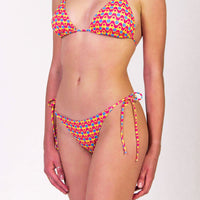 Bikini con triangolo e slip con laccetti in fantasia geometrica colore giallo, fucsia e blu, con interno e cuciture a contrasto colore blu Triangolo scorrevole con coppe estraibili Slip con laccetti sottili Morbida Lycra 100% Made in Italy 