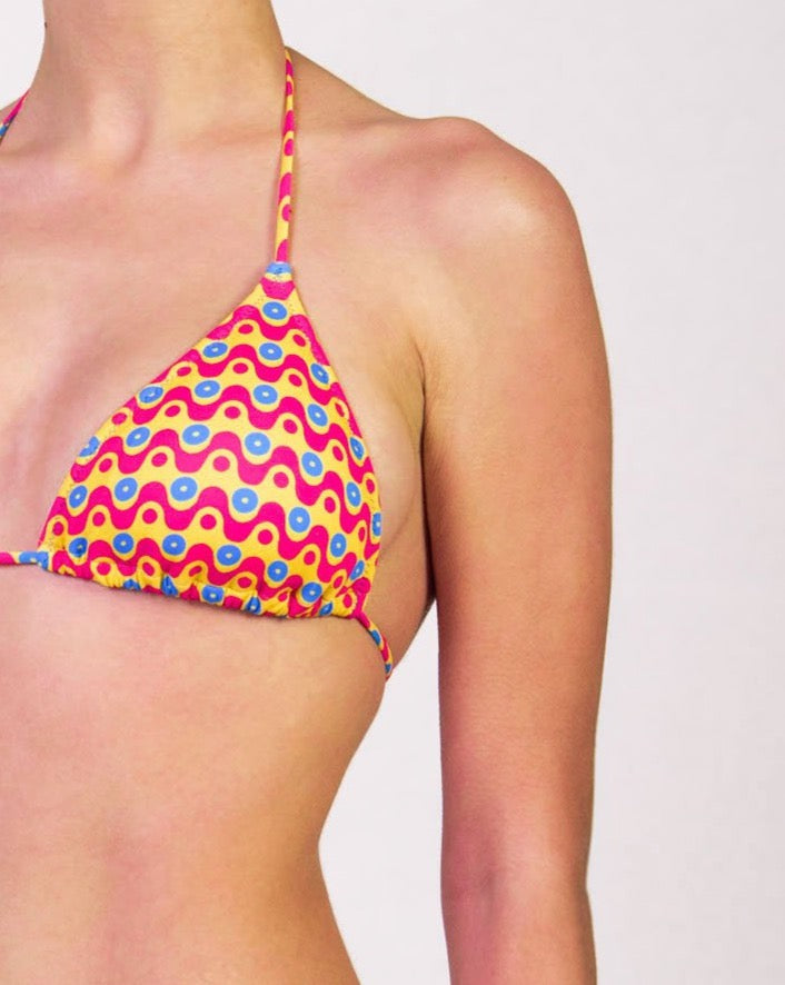 Bikini con triangolo e slip con laccetti in fantasia geometrica colore giallo, fucsia e blu, con interno e cuciture a contrasto colore blu Triangolo scorrevole con coppe estraibili Slip con laccetti sottili Morbida Lycra 100% Made in Italy 